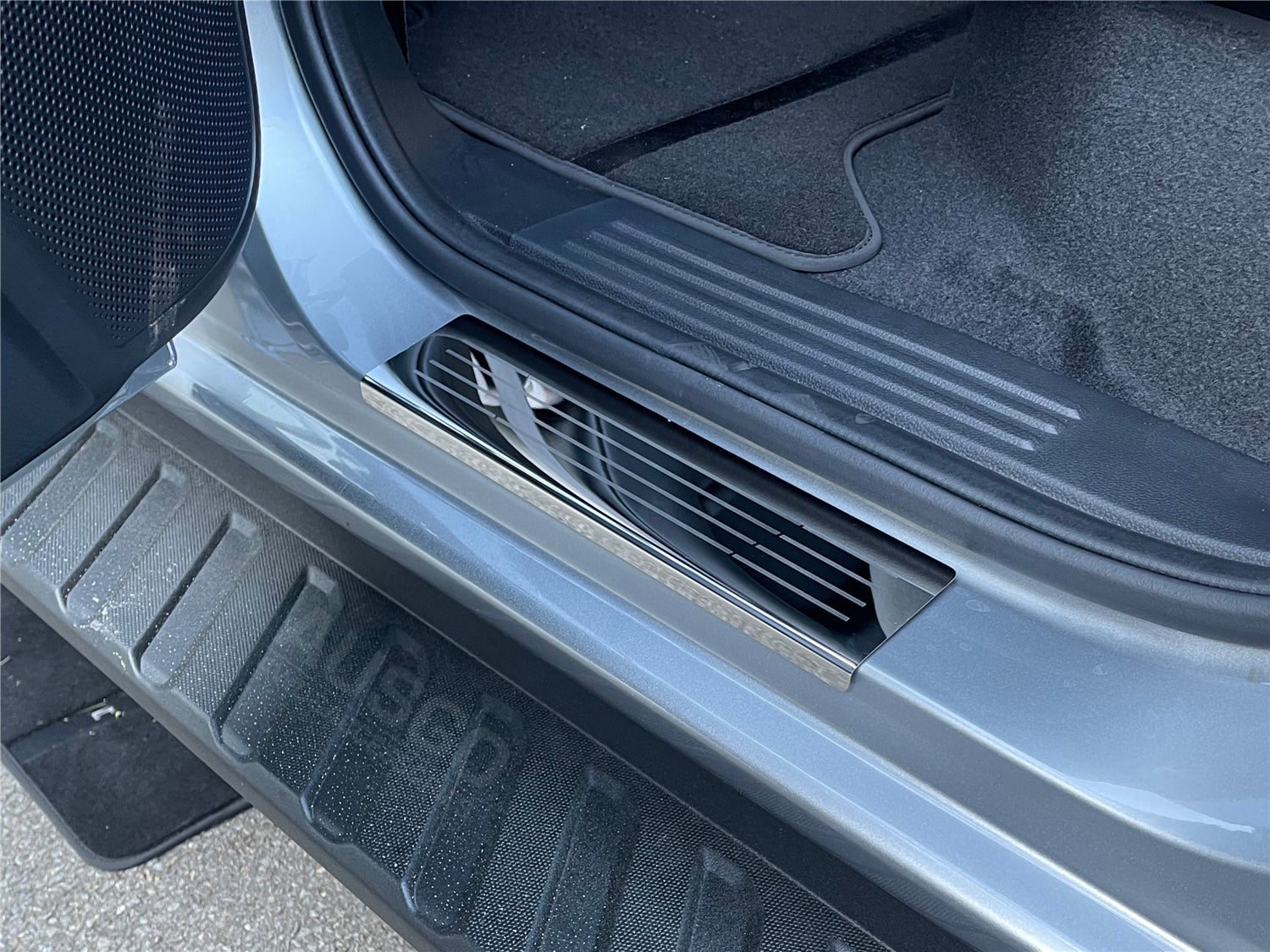 A zoomed in photo of a black door sill protector installed in a Ford Ranger.