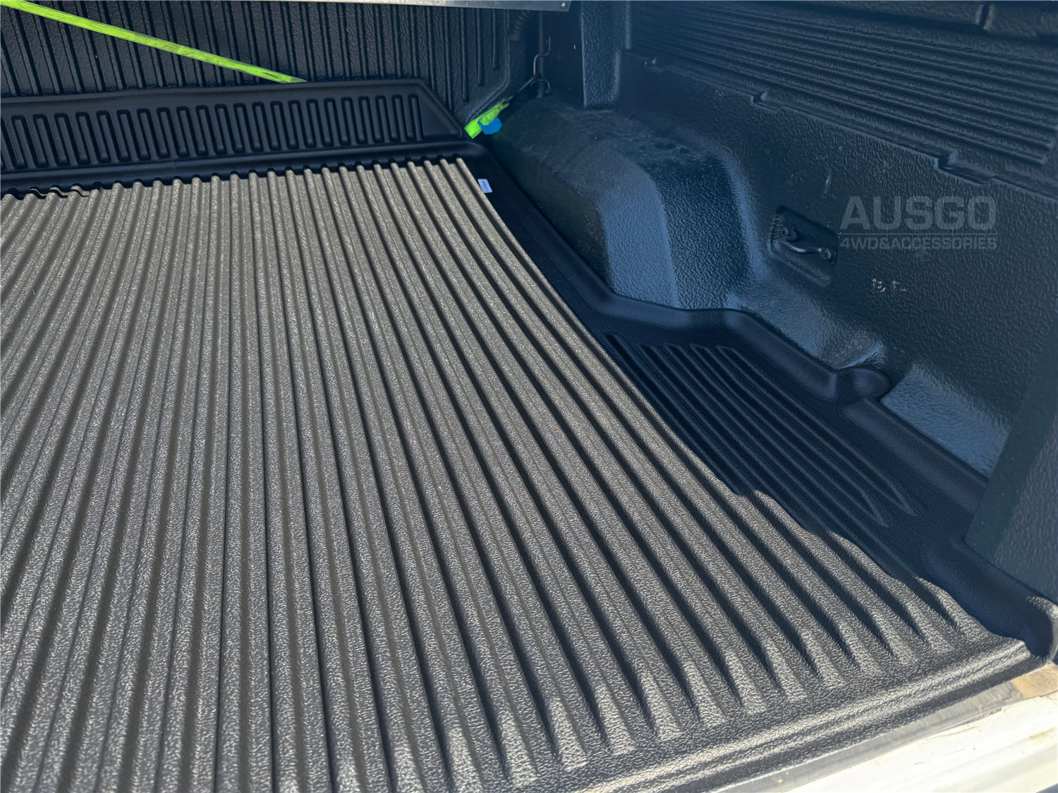 A zoomed in photo of a black AUSGO ute mat installed in the back of a ute.