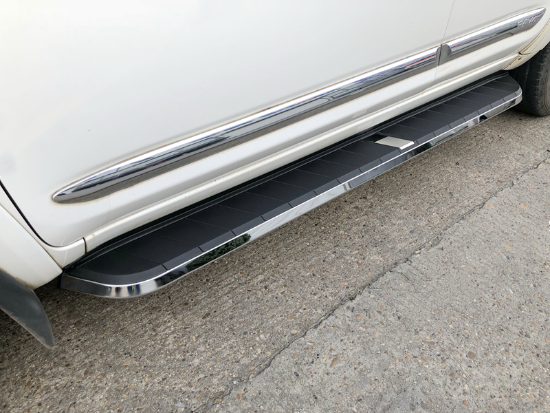 Black side steps installed on the side of a white Ford Kuga. 