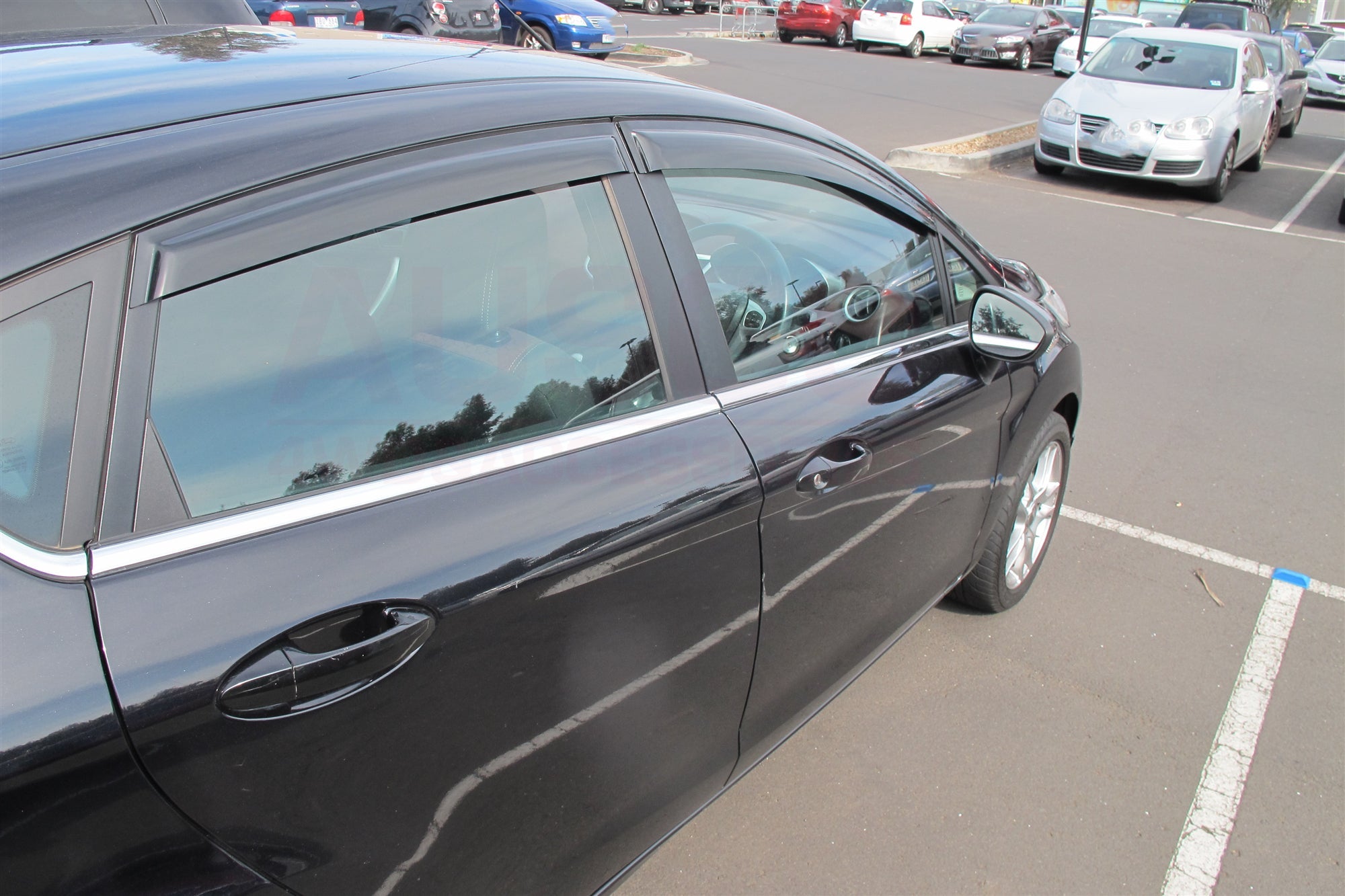 Side view of a black Ford Fiesta with weather shields attached to the windows. 
