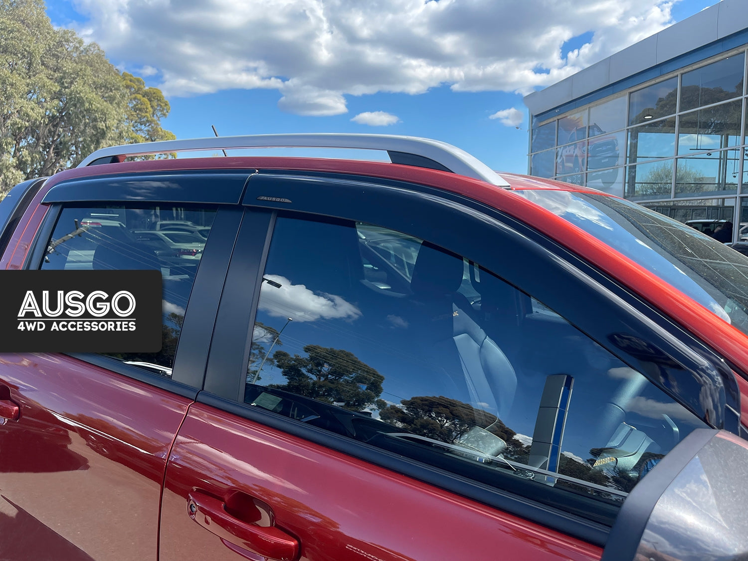 Side view of a red Ford Ranger with weather shields installed on the windows.